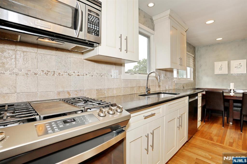 87 Barbara Road Dumont, NJ 07628 - Photo 18 of 48 a kitchen with granite countertop a stove and a sink
