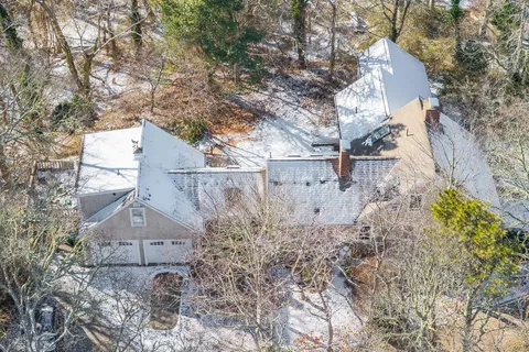 a front view of a house with garden and trees