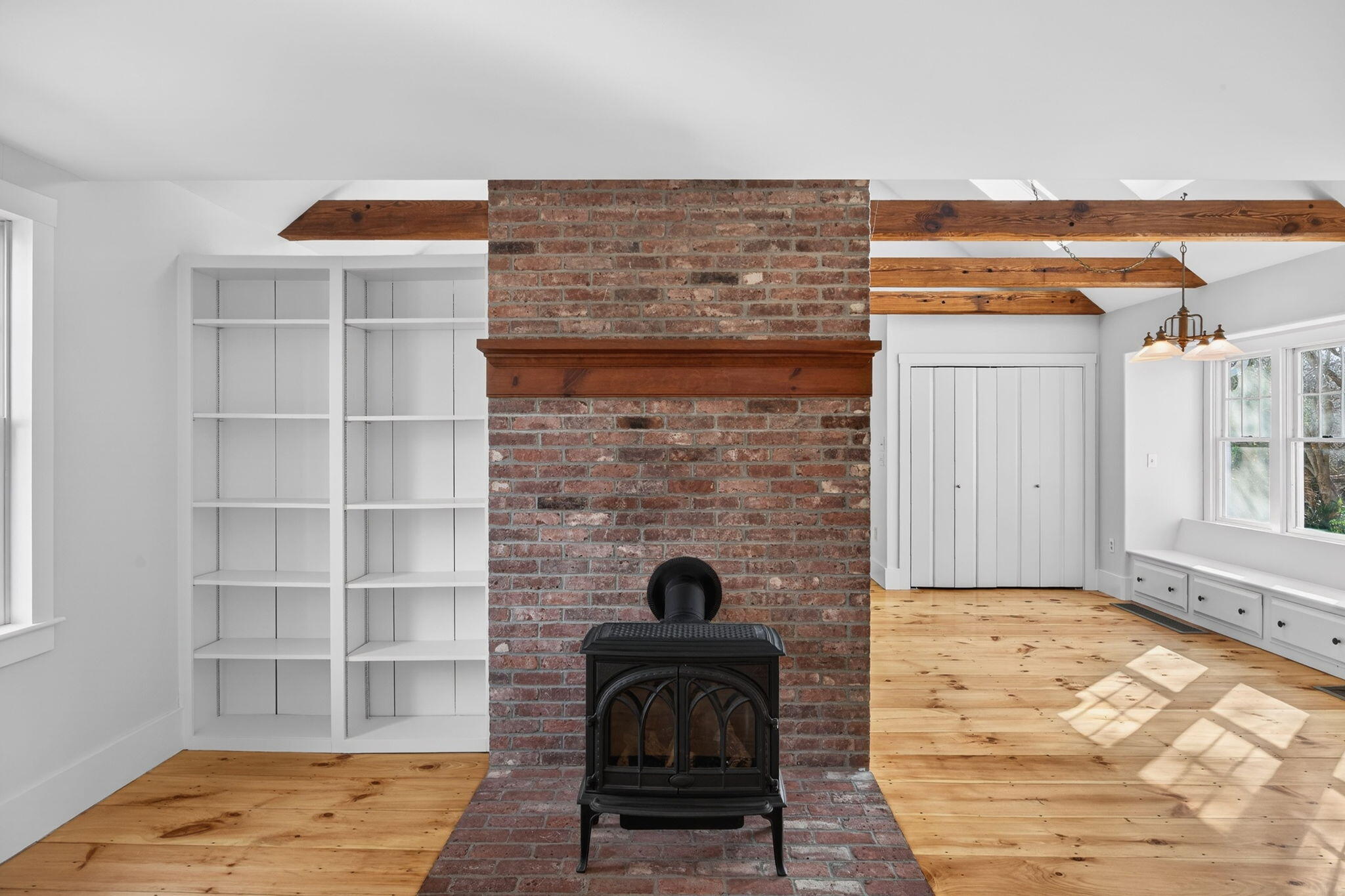 14 Bambi Way Orleans, MA 02653 - Photo 7 of 59 a living room with a fireplace and a walk in closet with wooden floor