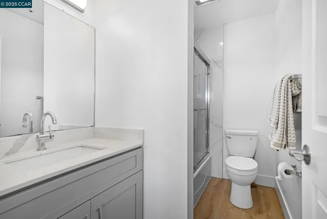 a bathroom with a granite countertop toilet sink and mirror
