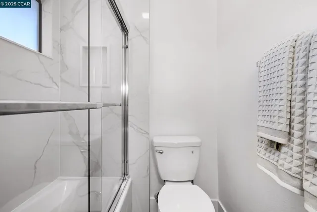 a bathroom with a toilet and a shower