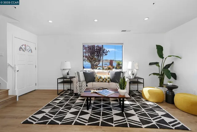 a living room with a rug and a wooden floor