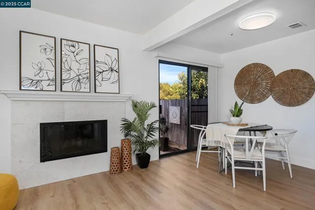 a living room with furniture a fireplace and potted plants