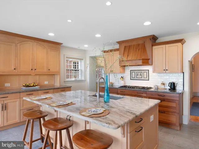 a kitchen with granite countertop kitchen island stainless steel appliances a sink a stove a table and chairs