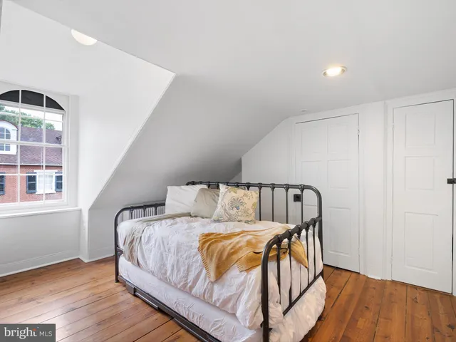 a spacious bedroom with a bed and a painting on the wall