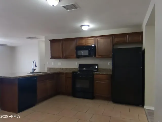 a kitchen with stainless steel appliances granite countertop a refrigerator and a sink