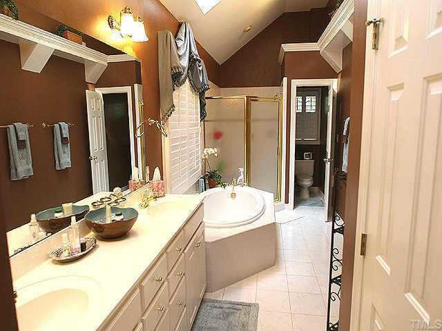 1408 Kings Branch Way Raleigh, NC 27614 - Photo 8 of 9 Master Bath offers large garden tub plus an all-tile, dual-head shower with bench, double sink vanity and walk-in closet. Custom paint gives this space a designer's flair and skylights let the natural light flow in! Other