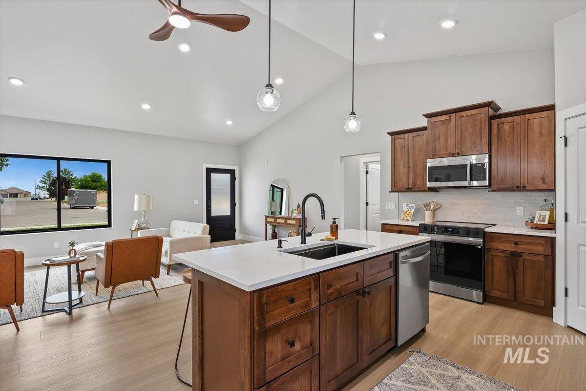 1201 Jade Drive Rupert, ID 83350 - Photo 10 of 27 Open-concept living space featuring wood-finish flooring and a vaulted ceiling with recessed lighting