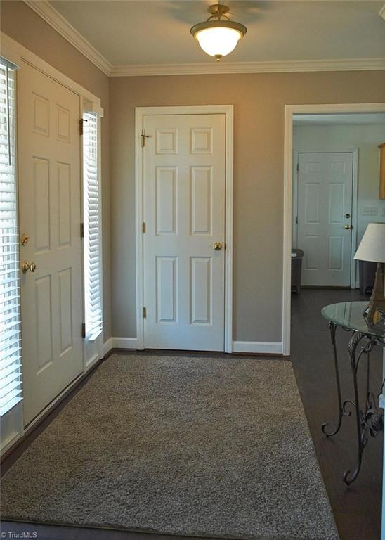 8117 Chestershire Road Oak Ridge, NC 27310 - Photo 8 of 50 Coat closet in the entry. Door on the right leads from the kitchen to the 2 car garage.