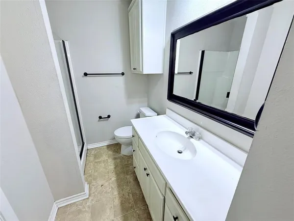 a bathroom with a sink a toilet and a mirror