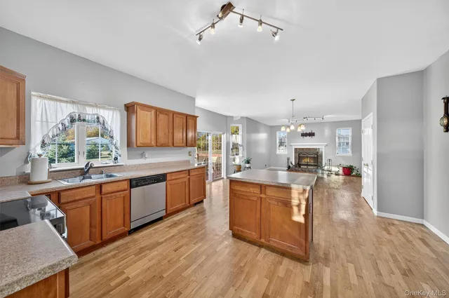 a large kitchen with stainless steel appliances granite countertop a lot of counter space and wooden floor