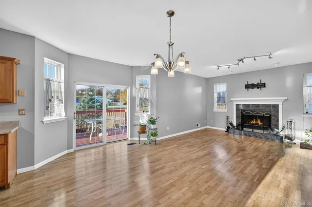 a view of empty room with wooden floor and fireplace