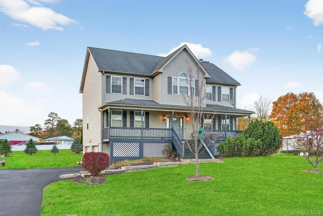 a front view of a house with a yard and green space