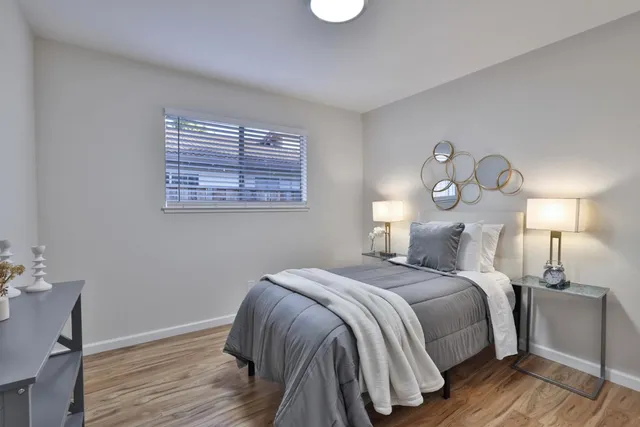 a bedroom with a bed and wooden floor
