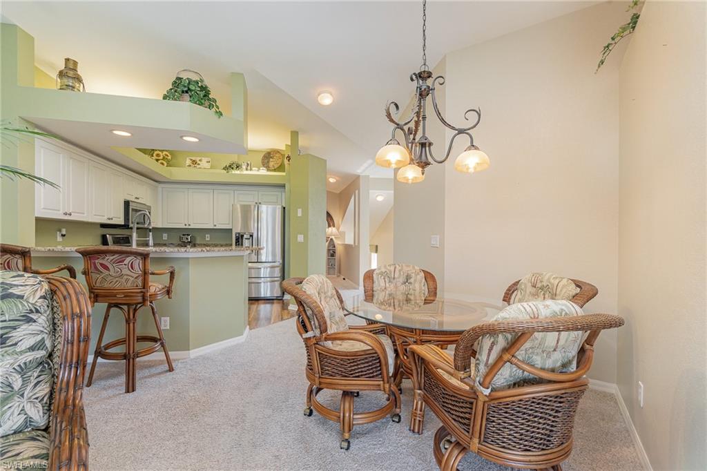10921 Oak Island Road, Unit 203 Estero, FL 34135 - Photo 11 of 25 a dining room with furniture and a chandelier