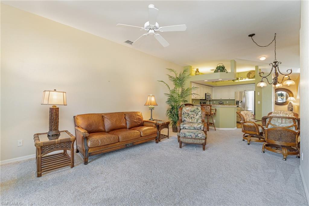 10921 Oak Island Road, Unit 203 Estero, FL 34135 - Photo 14 of 25 a living room with furniture and a chandelier
