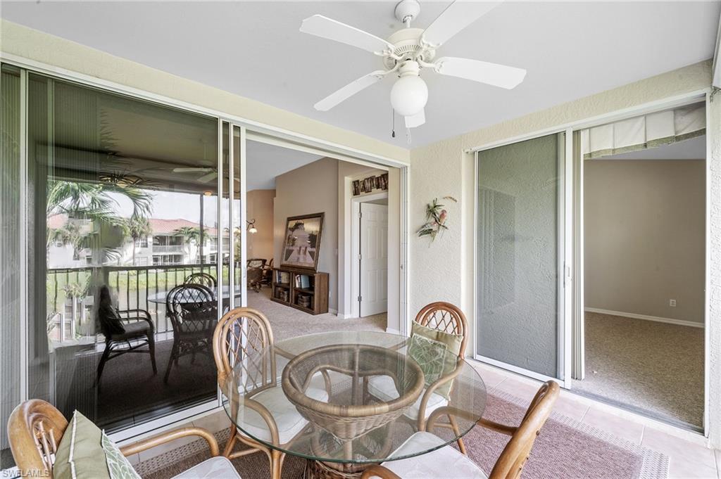 10921 Oak Island Road, Unit 203 Estero, FL 34135 - Photo 22 of 25 a view of a livingroom with furniture window wooden floor and a chandelier fan
