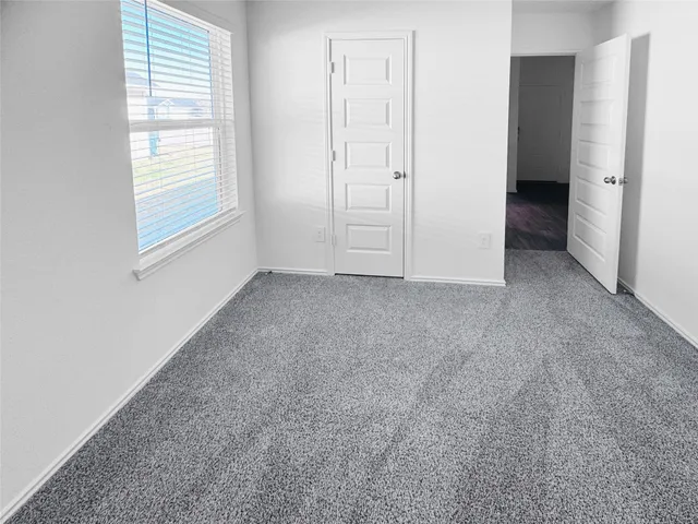 an empty room with windows and closet