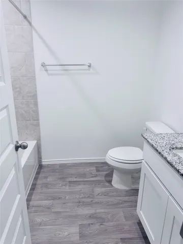 a white toilet sitting next to a bath tub