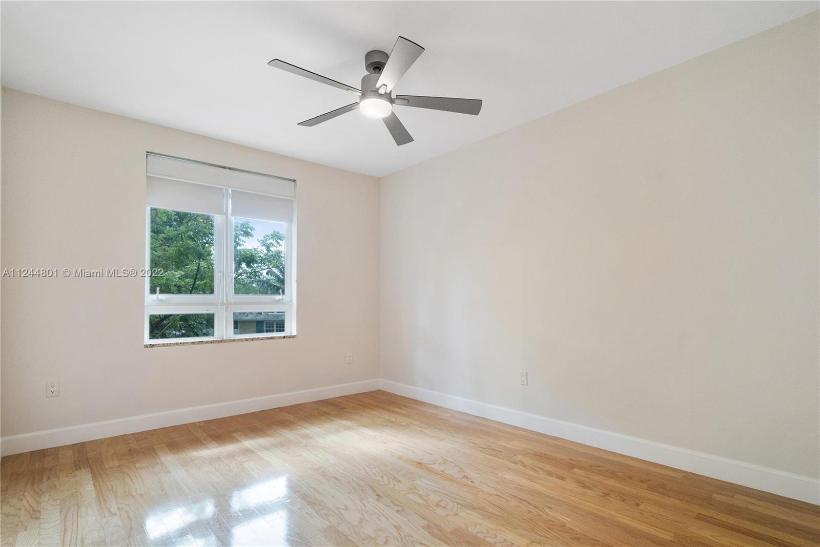 3540 Main Highway, Unit 309 Miami, FL 33133 - Photo 13 of 34 an empty room with wooden floor fan and windows