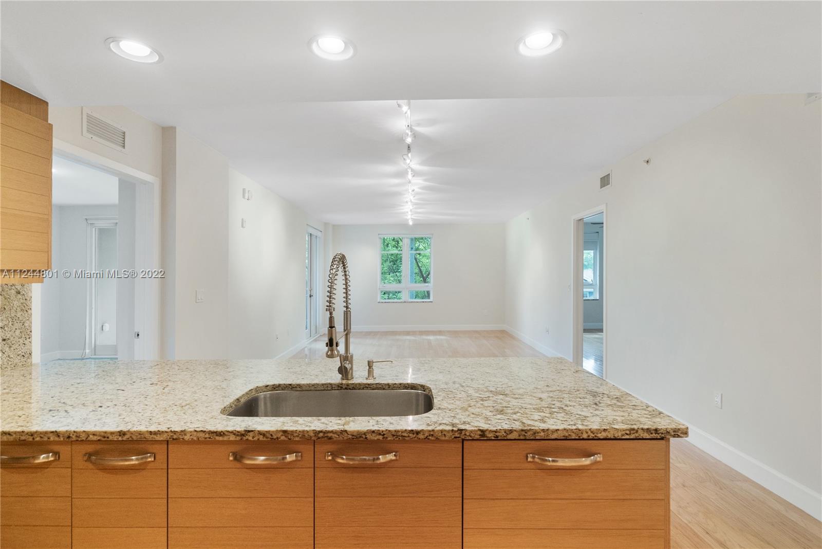3540 Main Highway, Unit 309 Miami, FL 33133 - Photo 2 of 34 a kitchen with kitchen island granite countertop a sink and a window