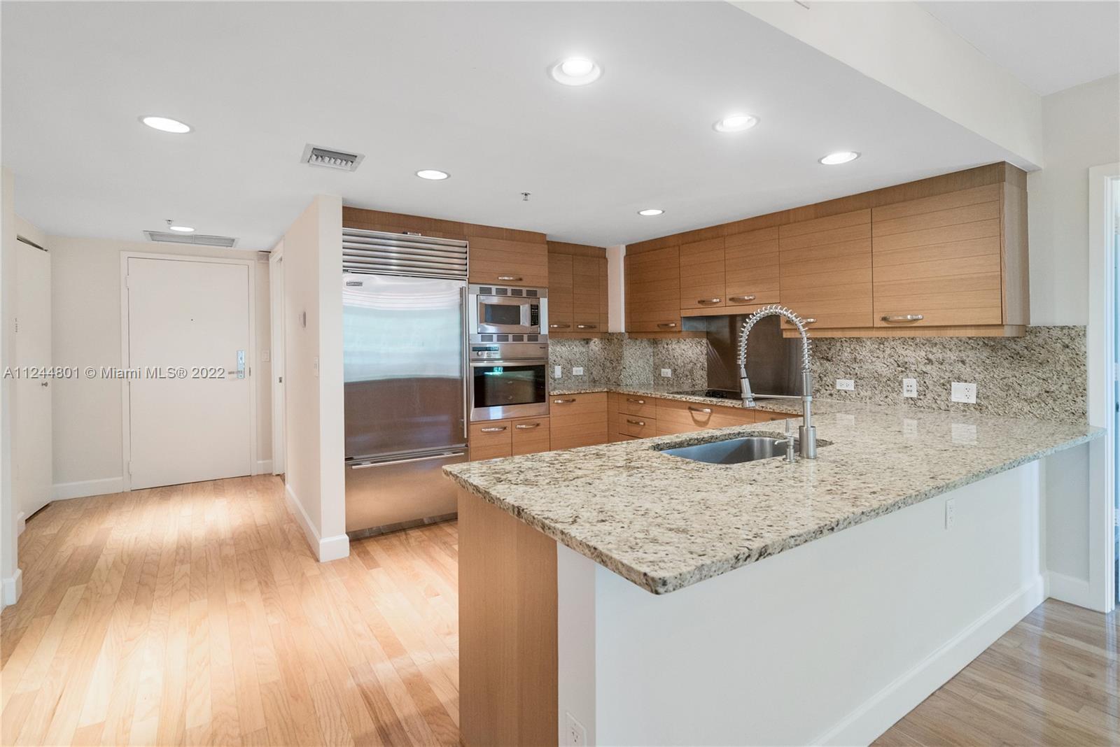 3540 Main Highway, Unit 309 Miami, FL 33133 - Photo 6 of 34 a kitchen with stainless steel appliances granite countertop a sink and a refrigerator