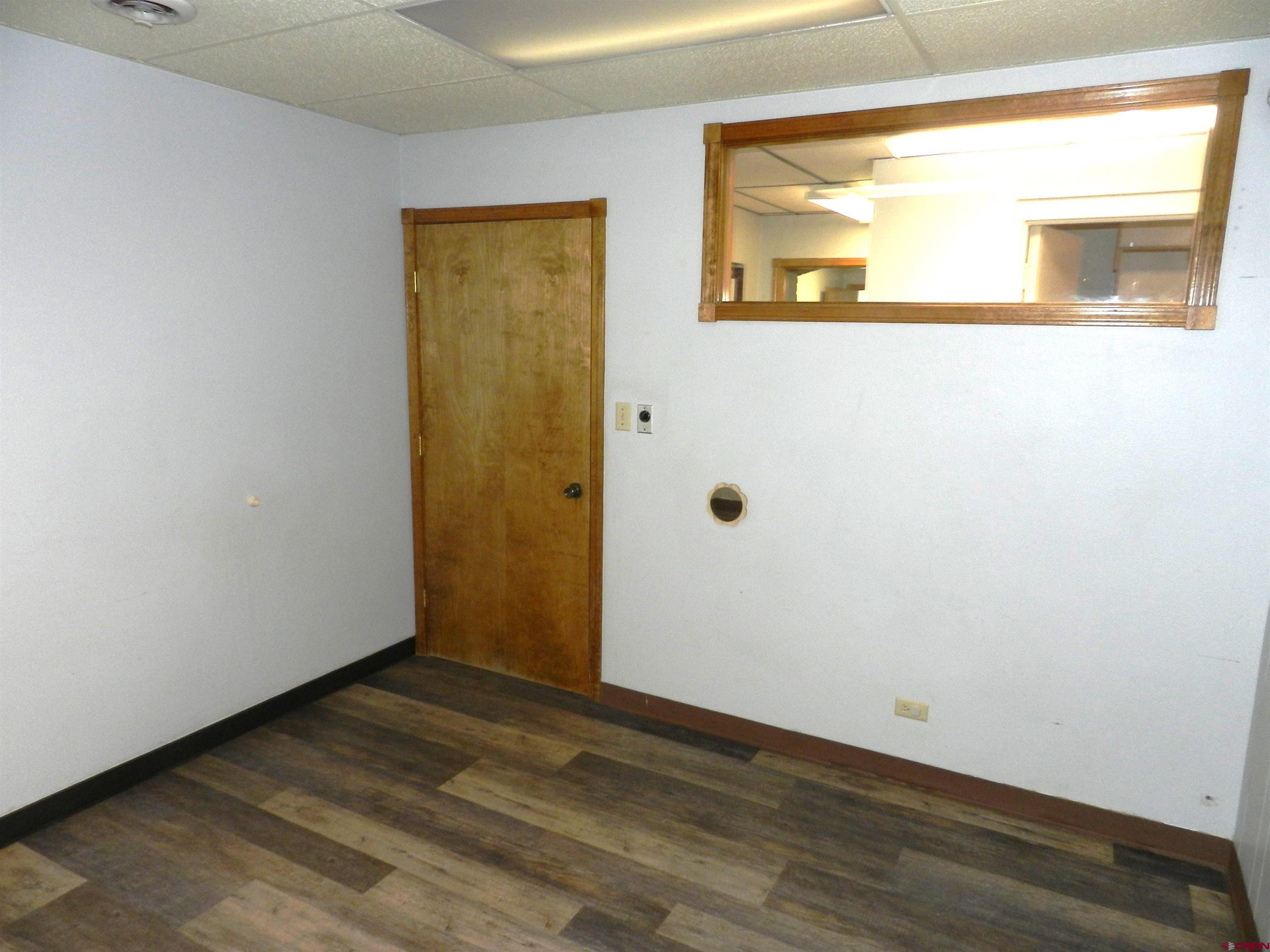 18 North Uncompahgre Avenue, Unit BACK SECTION OF 501 E MAIN BUILDING Montrose, CO 81401 - Photo 13 of 24 a view of a small space with wooden floor and a window