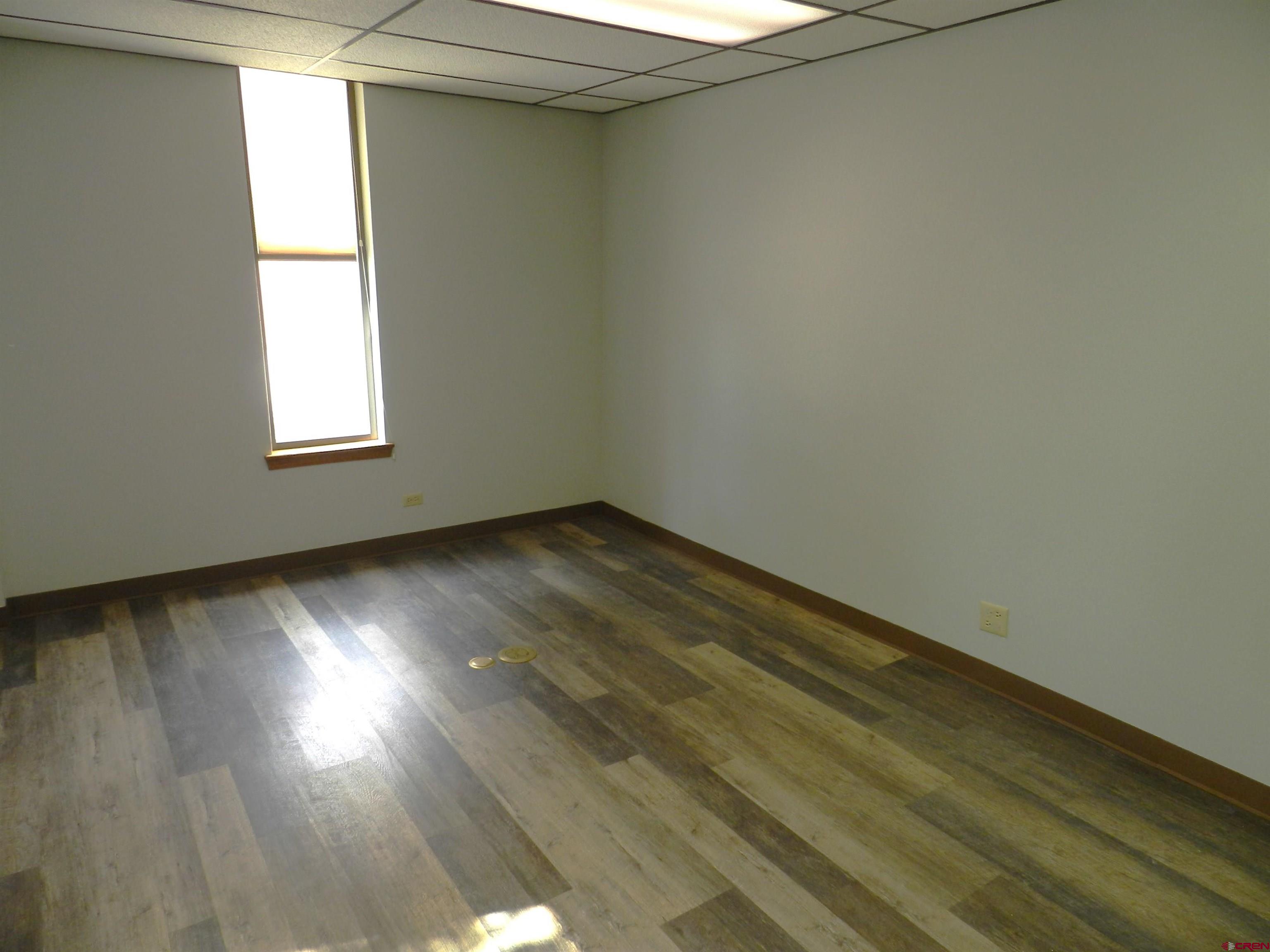 18 North Uncompahgre Avenue, Unit BACK SECTION OF 501 E MAIN BUILDING Montrose, CO 81401 - Photo 19 of 24 an empty room with wooden floor and windows