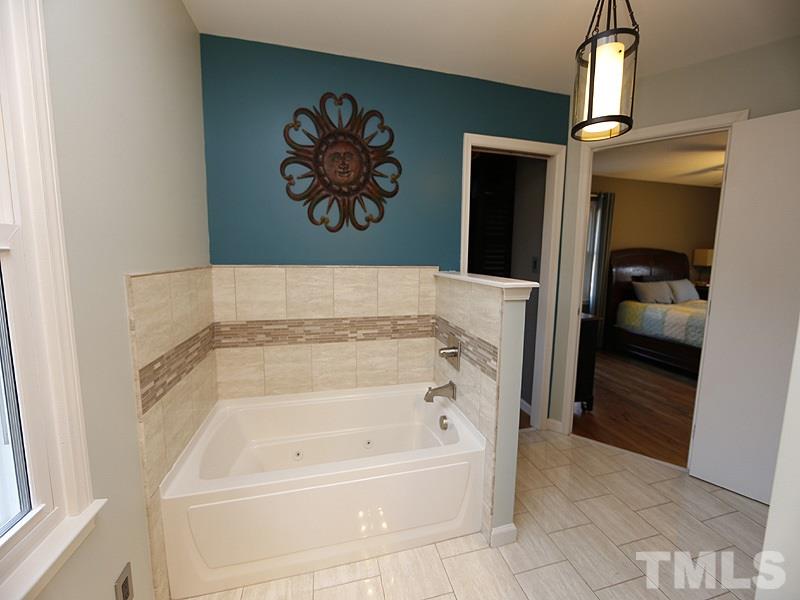 7209 Fiesta Way Raleigh, NC 27615 - Photo 13 of 24 a bathroom with a bathtub and a shower
