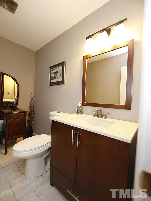 7209 Fiesta Way Raleigh, NC 27615 - Photo 18 of 24 a bathroom with a toilet sink and mirror