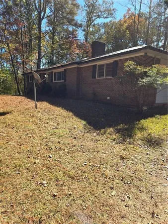 a view of backyard with swimming pool and seating