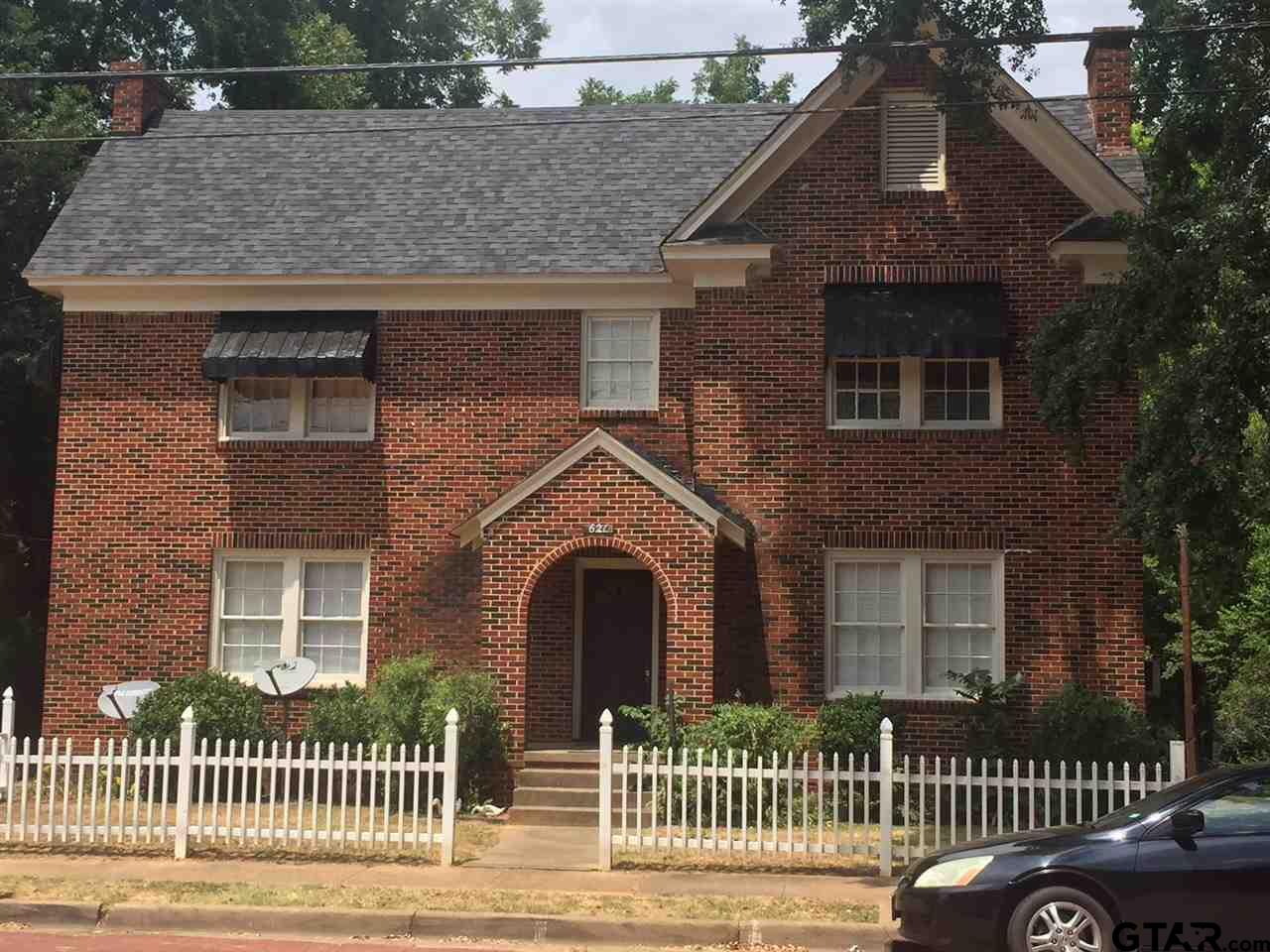 a view of a brick house with many windows