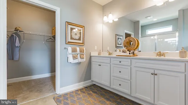 a spacious bathroom with a double vanity sink a mirror and a shower