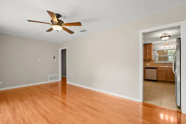 a view of a livingroom with a ceiling fan and kitchen floor