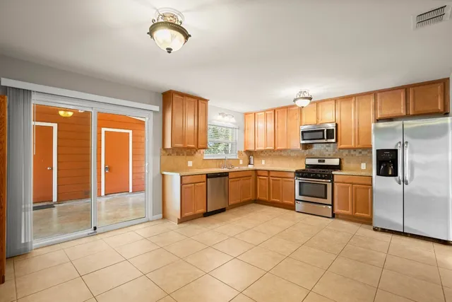 a kitchen with stainless steel appliances granite countertop a stove a sink and a refrigerator