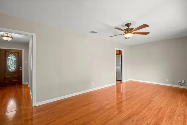 a view of a livingroom with wooden floor and a ceiling fan