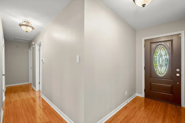 a view of a hallway with entryway wooden floor and front door