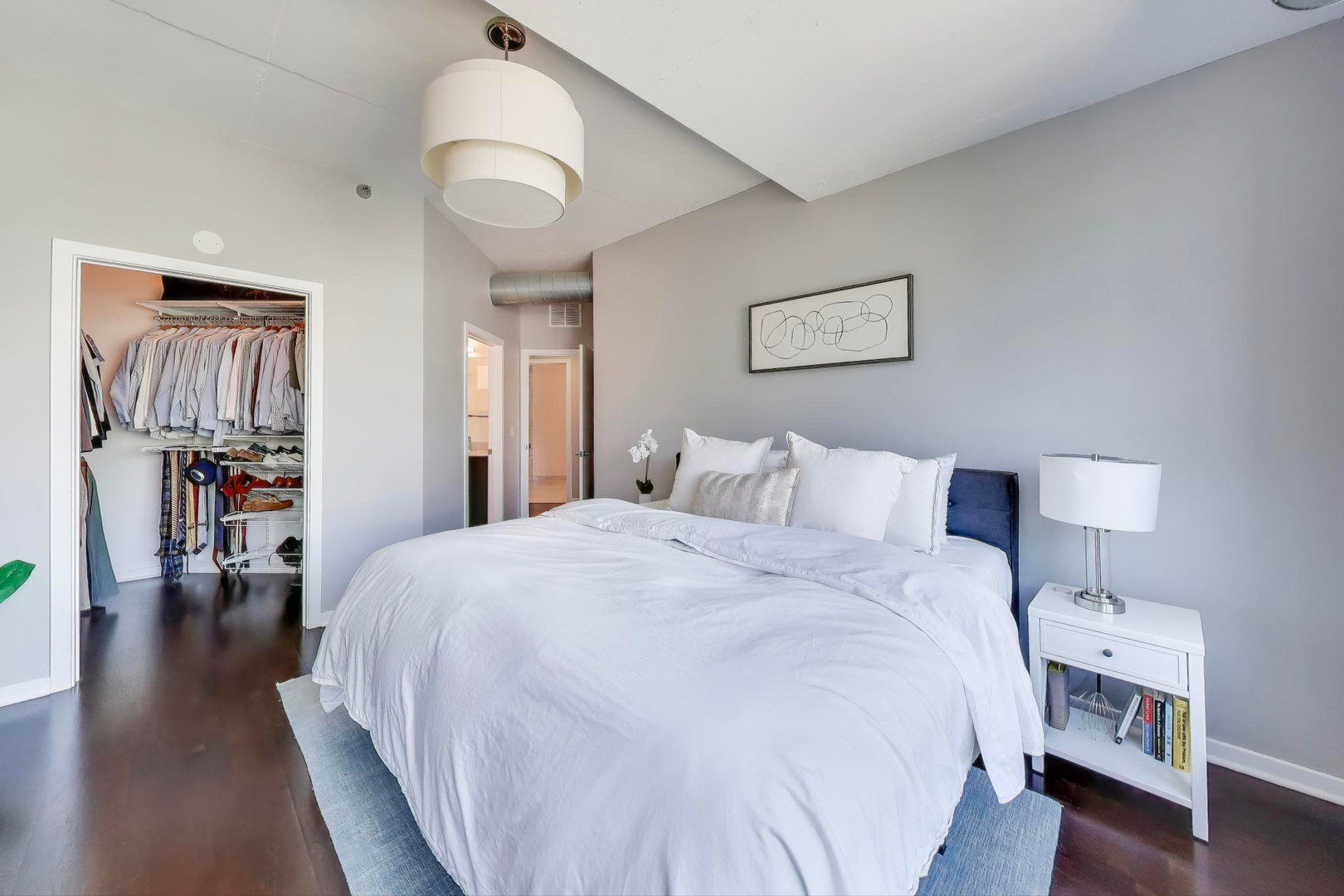 909 West Washington Boulevard, Unit 908 Chicago, IL 60607 - Photo 12 of 26 a bedroom with a bed and wooden floor