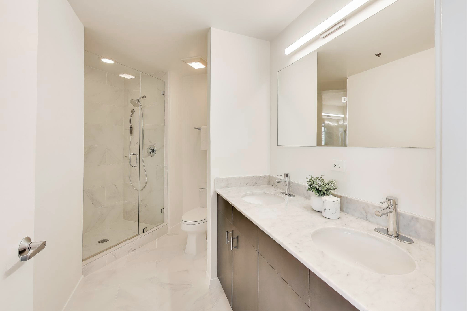 909 West Washington Boulevard, Unit 908 Chicago, IL 60607 - Photo 16 of 26 a bathroom with a double vanity sink mirror and shower