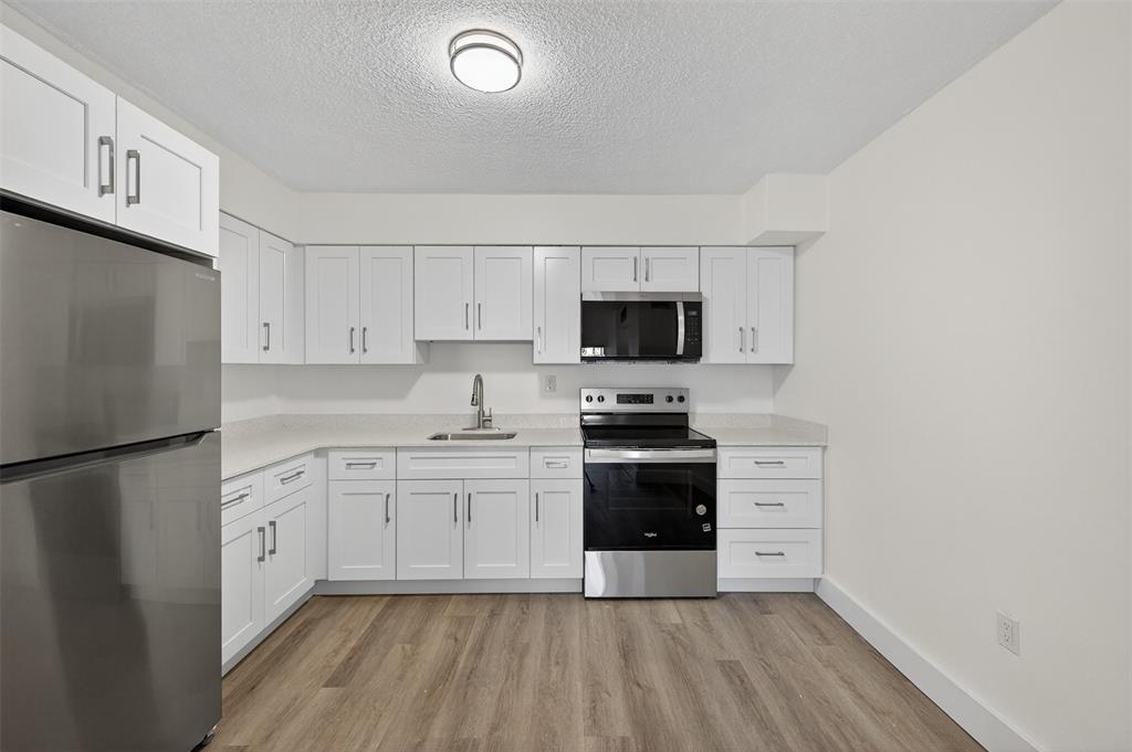 2465 Southwest 18th Avenue, Unit 3206 Miami, FL 33133 - Photo 6 of 19 a kitchen with stainless steel appliances a refrigerator stove microwave and sink