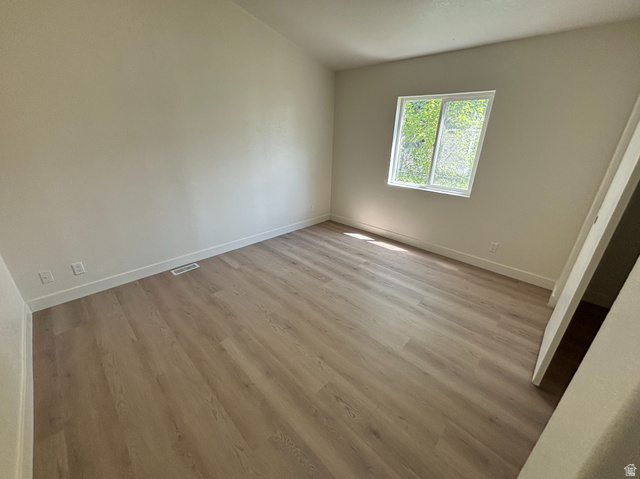 11313 South 265 East Sandy, UT 84070 - Photo 11 of 21 Room featuring light-toned walls, wood-finish flooring, and a single window