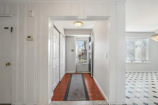 a view of a hallway with wooden floor and a bathroom