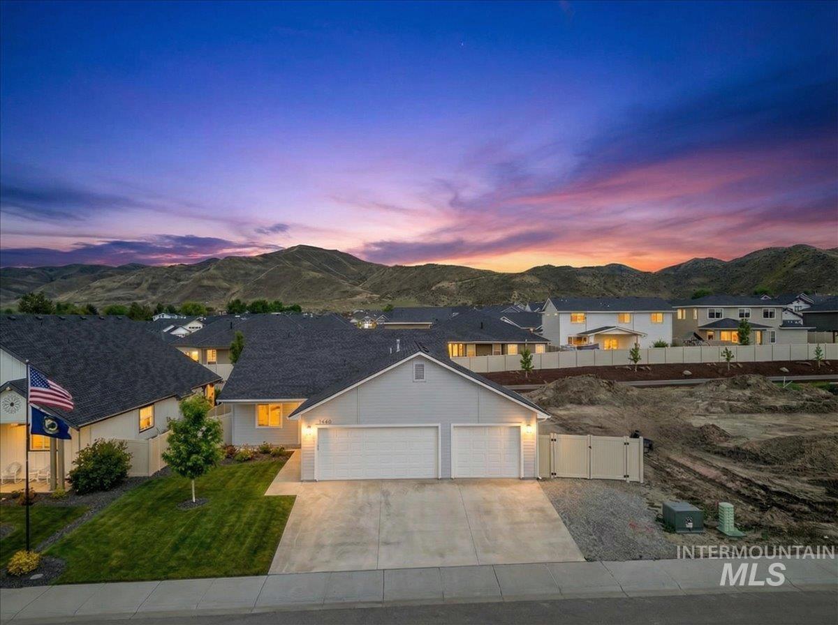 1440 Castle Way Emmett, ID 83617 - Photo 1 of 1 View of front facade with a gate, an attached garage, concrete driveway, a mountain view, and a residential view