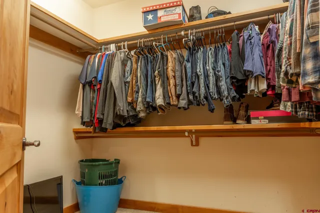 a view of walk in closet with clothes and shoes