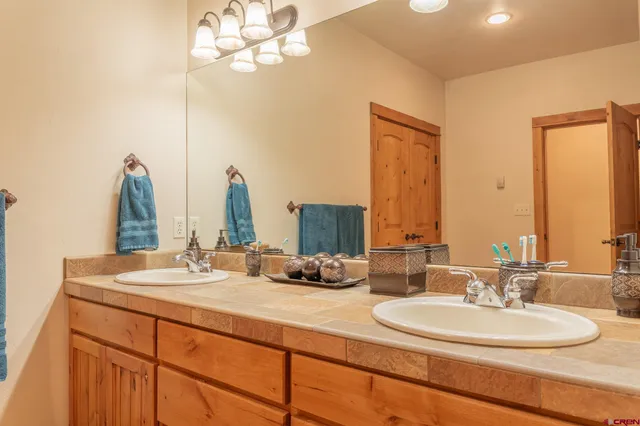 a bathroom with double vanity sinks and a mirror