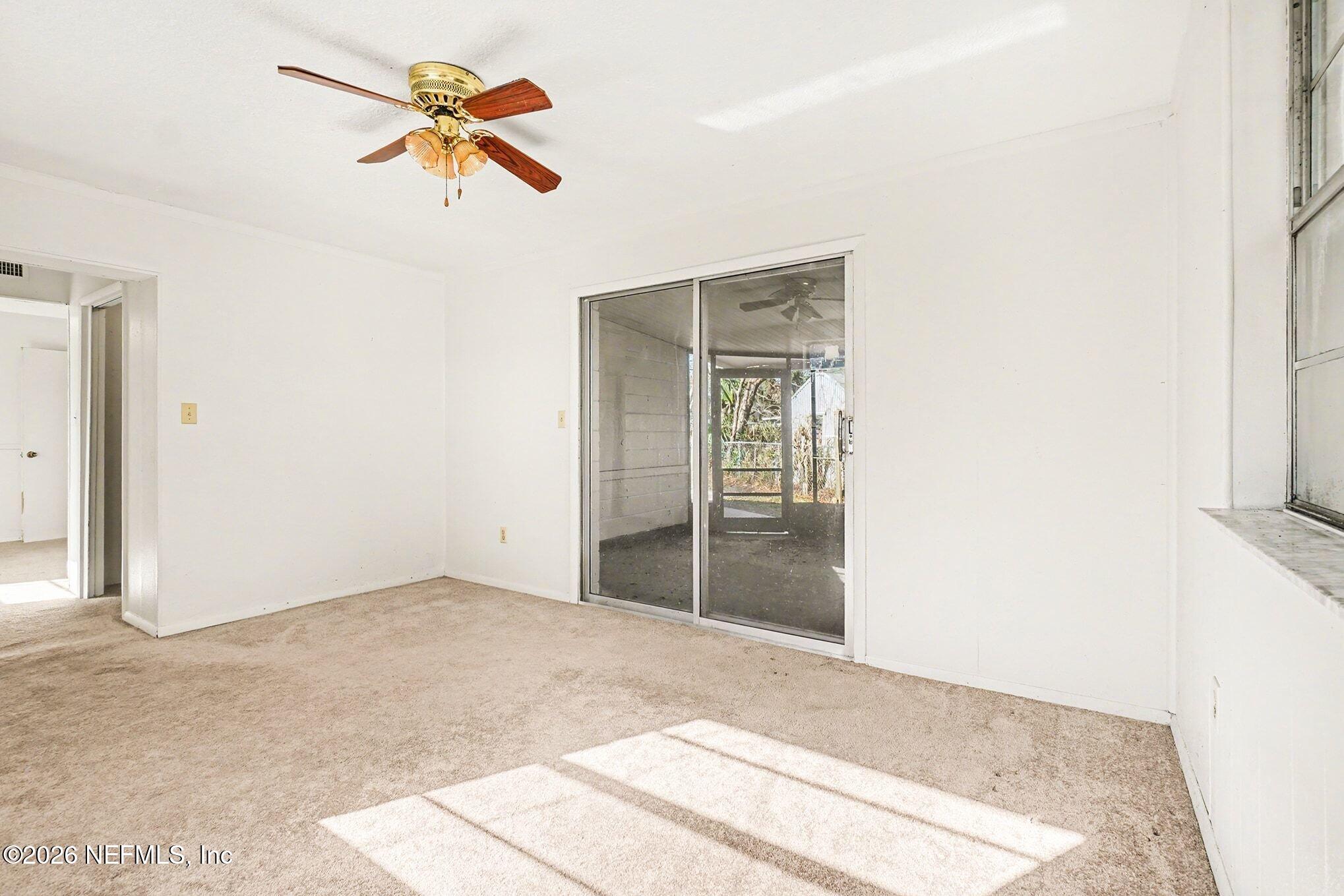 3661 Calla Drive Jacksonville, FL 32207 - Photo 11 of 16 a view of a room with wooden floor and a ceiling fan