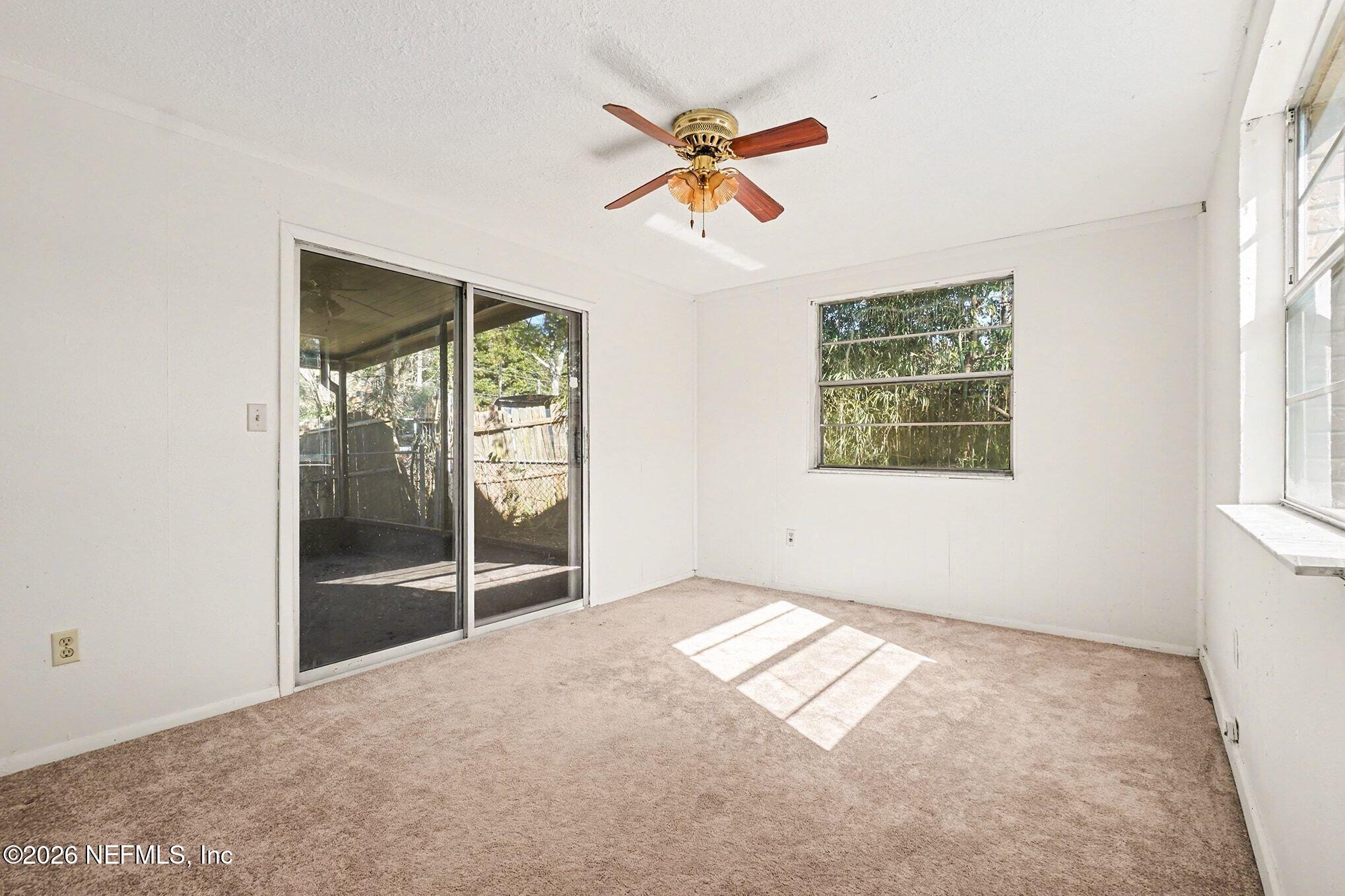 3661 Calla Drive Jacksonville, FL 32207 - Photo 12 of 16 an empty room with windows and fan