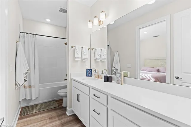a bathroom with a double vanity sink toilet mirror and shower
