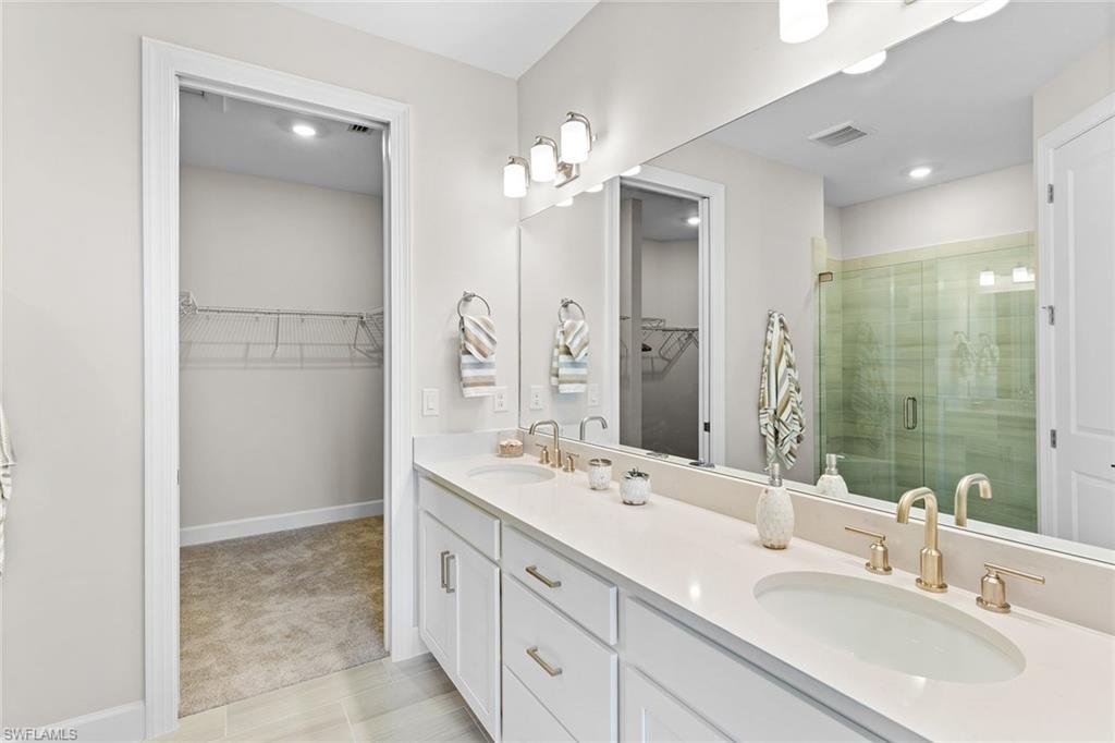 15657 Gavello Street Naples, FL 34114 - Photo 19 of 37 a bathroom with a double vanity sink mirror and shower