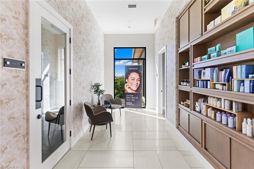 15657 Gavello Street Naples, FL 34114 - Photo 30 of 37 a living room with furniture a book shelf and a book shelf